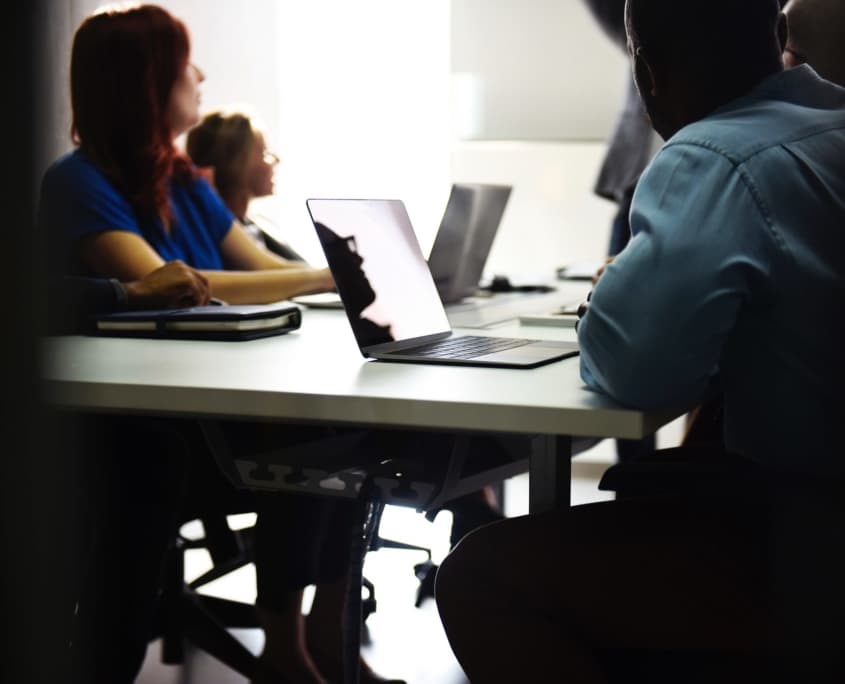People at a desk with laptops