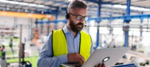Man in safety vest with laptop