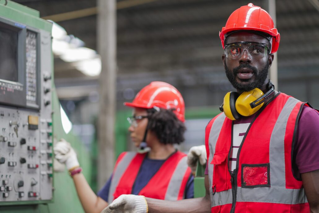 Factory Workers Wearing Hard Hats and Red Safety Vests