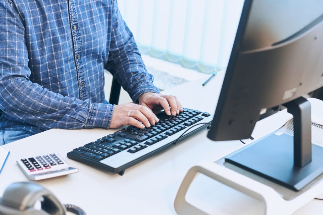 A business man's hands typing on a computer