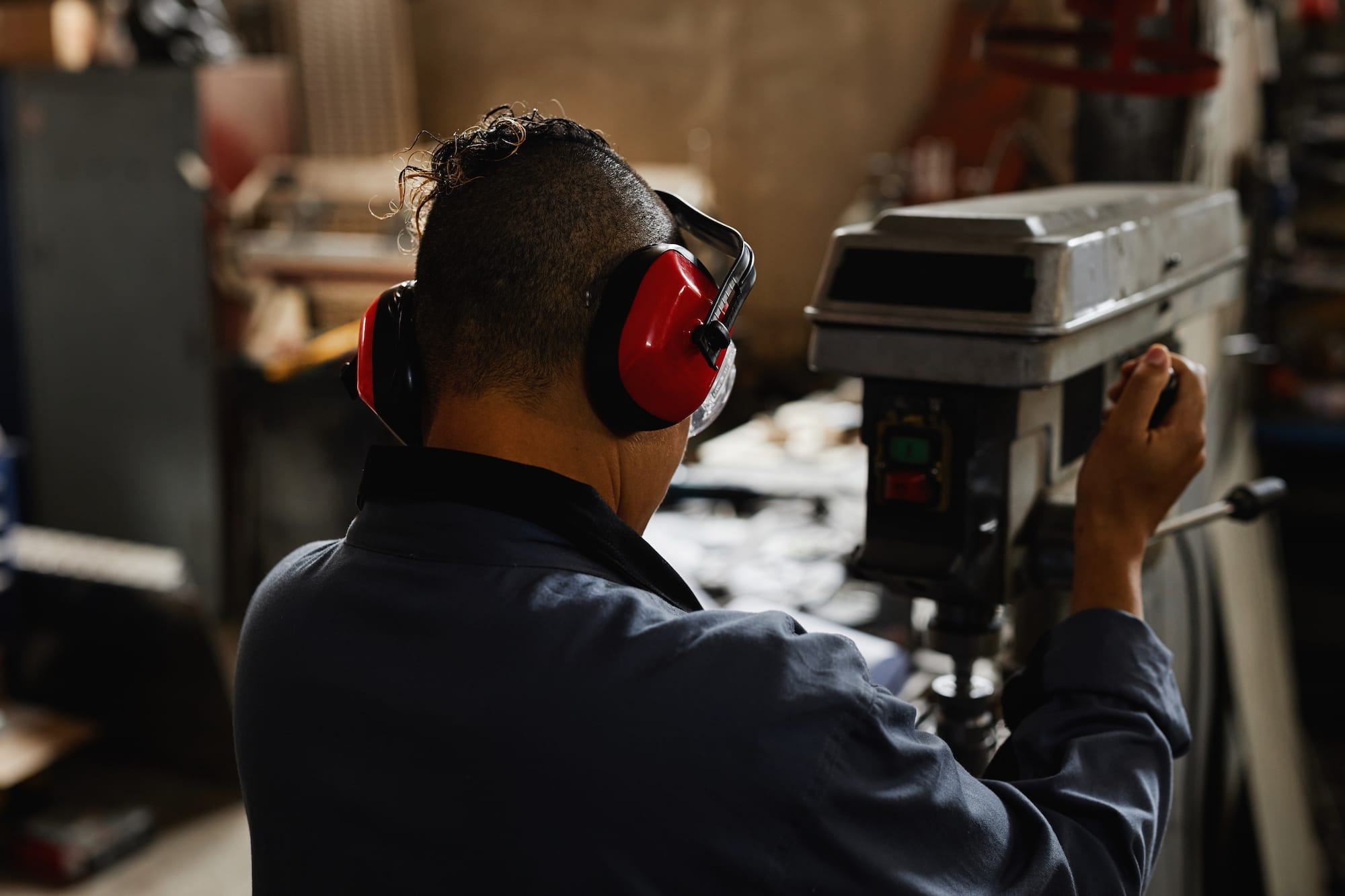 Man wearing red ear muffs in factory