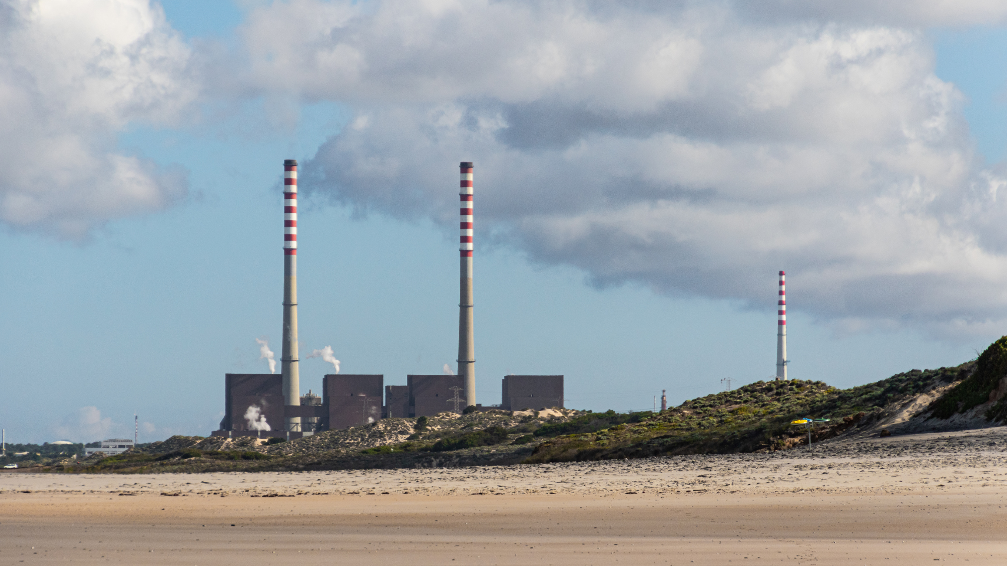 Factory with smoke stacks on the beach