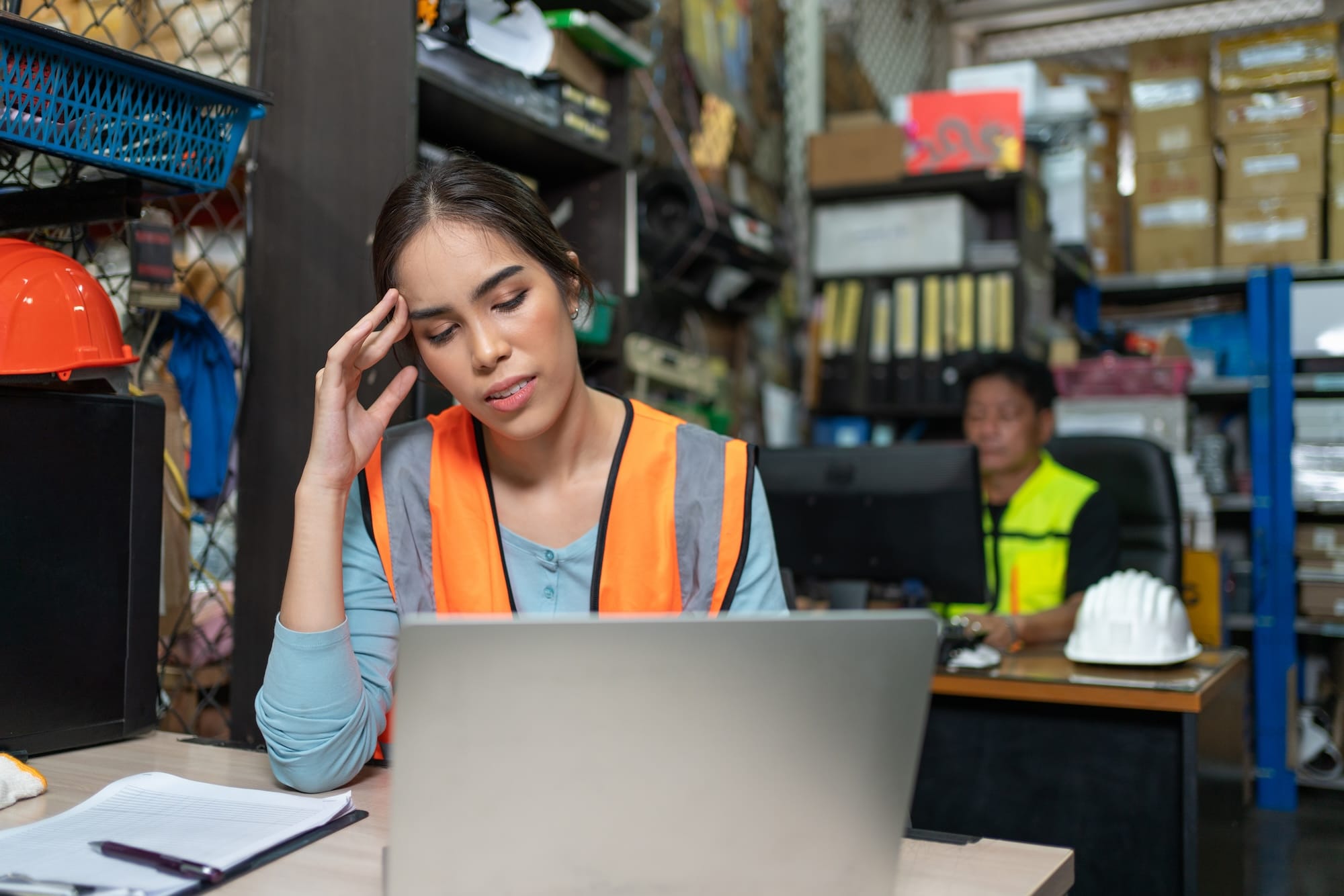Woman with safety vest in front of laptop