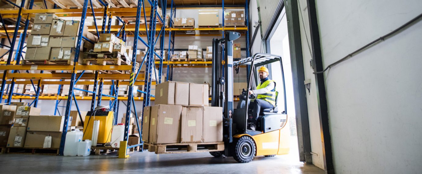 Man forklift driver working in a warehouse.