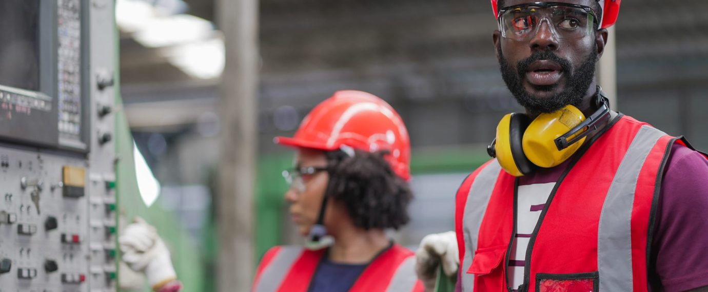 Factory Workers Wearing Hard Hats and Red Safety Vests