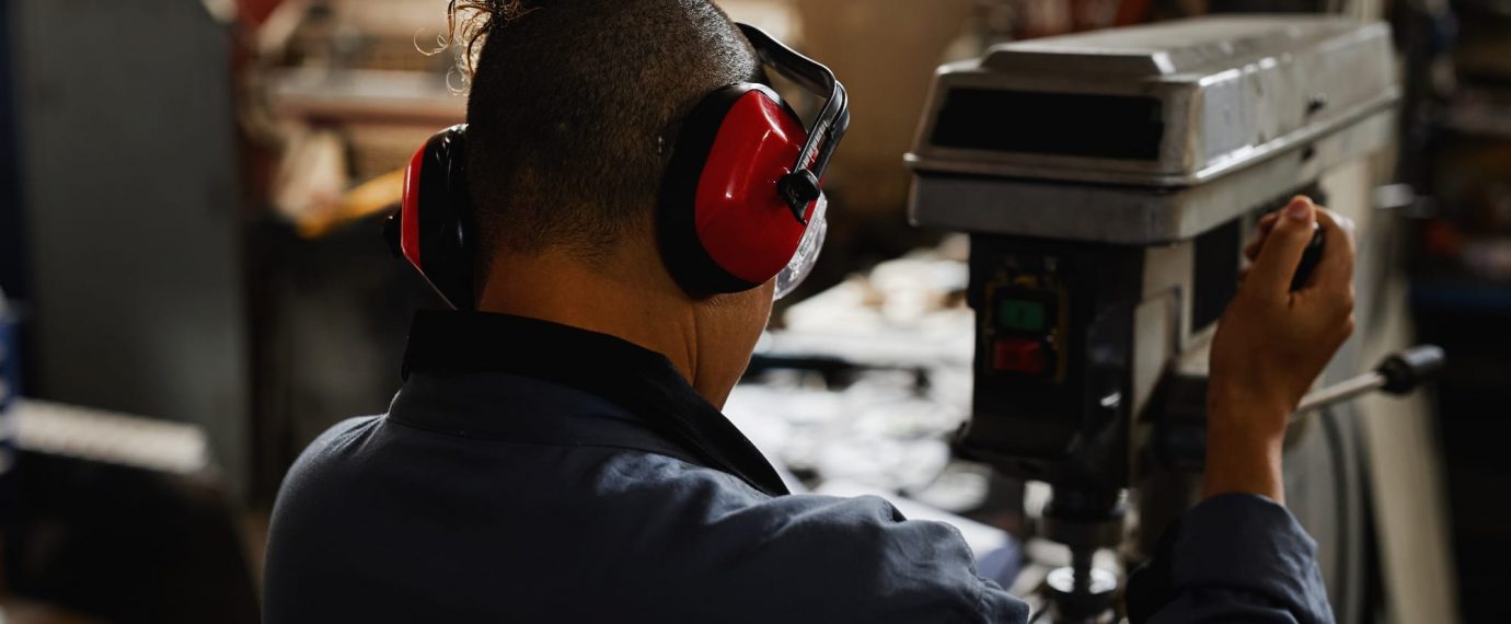 Man wearing red ear muffs in factory