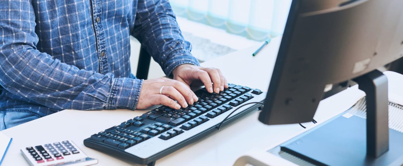 A business man's hands typing on a computer