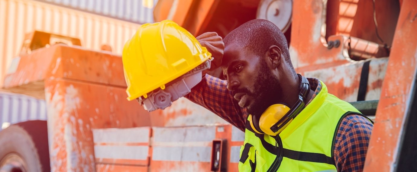 Tired stress worker sweat from hot weather in summer working in port goods cargo shipping logistic ground, Black African race people. (Tired stress worker sweat from hot weather in summer working in port goods cargo shipping logistic ground, Black Afr